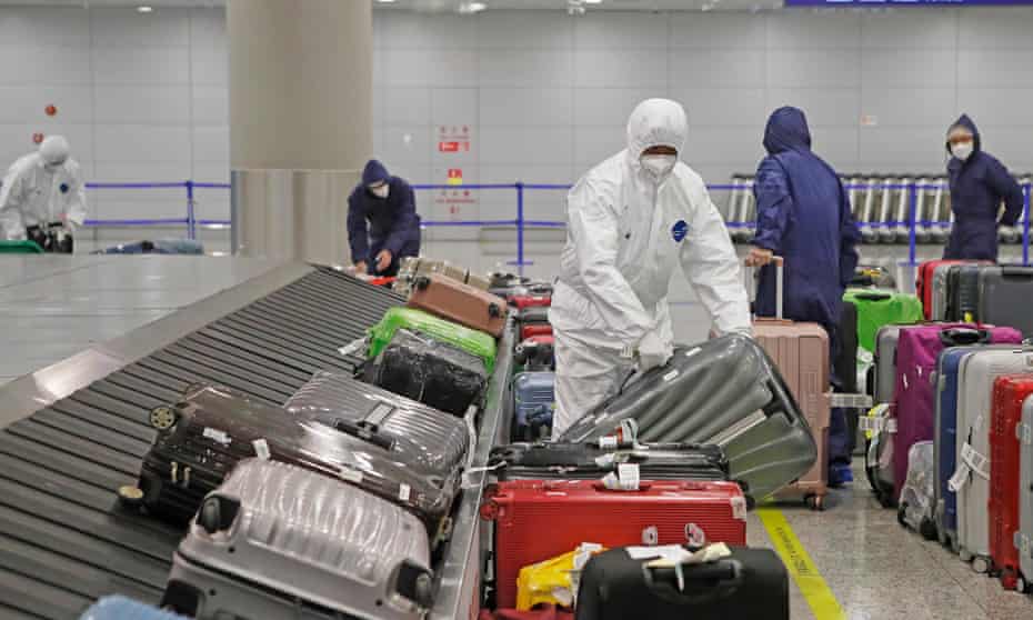 Workers wearing protective suits at Shanghai Pudong International Airport