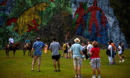 Tourists look at the Mural of Prehistory in Viñales, Pinar del Río province, Cuba
