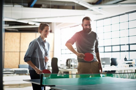 Office workers playing table tennis