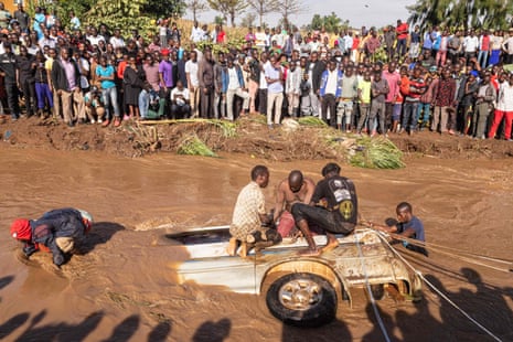Villagers try to retrieve bodies from a minibus partly submerged in the Nabuyonga River in Namakwekwe, eastern Uganda
