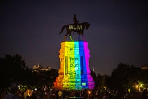 The Pride rainbow colors are projected over a statue of Confederate general Robert E Lee, adorned with BLM for Black Lives Matter, that still stands in Richmond.