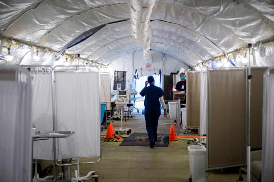 'The horror stories are countless': inside the LA hospital at the center of the Covid crisis | California 1 Kennoka Williamson, a registered nurse, attends to patients in a Covid-19 triage area set up in a field hospital tent outside the hospital.