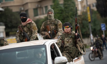 Men in combat gear and balaclavas holding guns in a white van