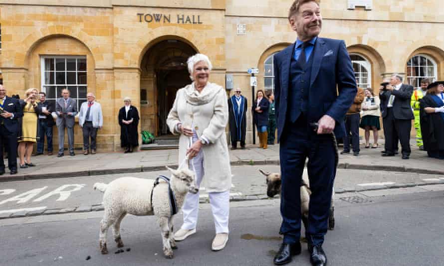 Judi Dench and Kenneth Branna with sheep outside the town hall.