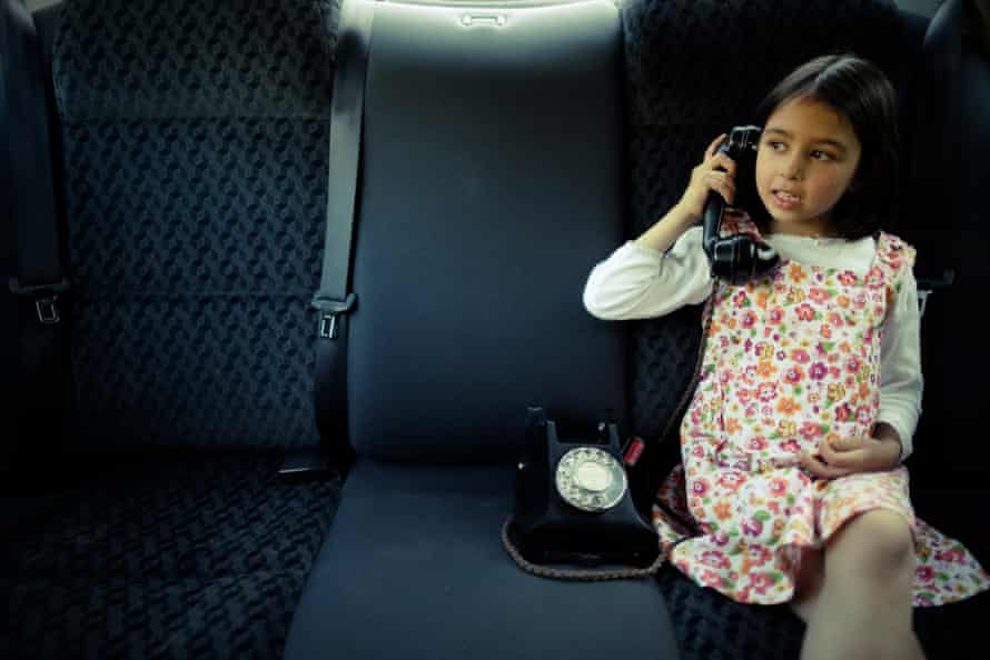 Car phoneGirl using a vintage Bakelite phone in the back seat of a car.