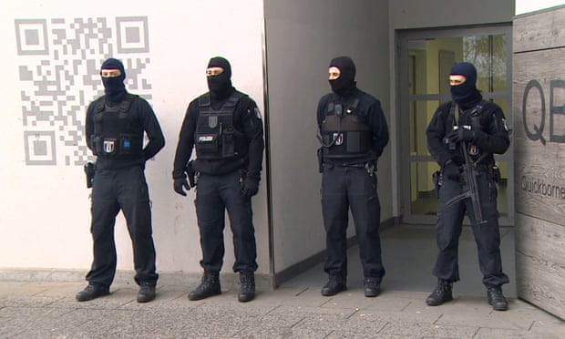 Police guard a residential building in Berlin after a raid in connection with the Fussilet 33 mosque