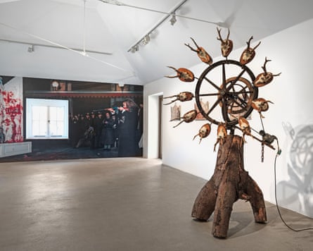 The Infernal Circle of Death by Tinguely, with Sant Phalle pictured in the background creating one of her shooting paintings.