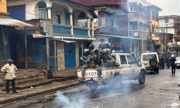 Αστυνομία ταραχών περιπολεί καθώς περνάει καπνός που αναδύεται από οδόφραγμα κατά τη διάρκεια αντικυβερνητικών διαδηλώσεων στο Freetown της Σιέρα Λεόνε.
