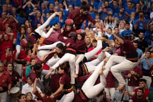 Members of the Colla Jove de Barcelona fall down as they build a human tower during a Concurs de Castells competition.