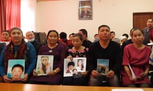 In this December image, Kazakh relatives of people missing in Xinjiang hold up photos of their loved ones.