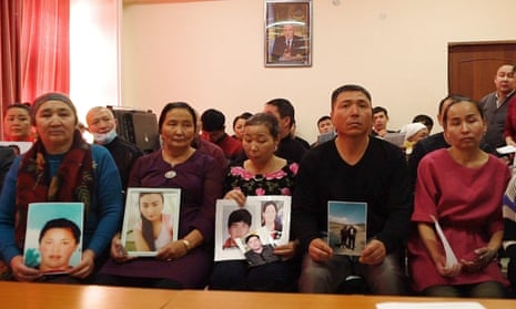 In this December image, Kazakh relatives of people missing in Xinjiang hold up photos of their loved ones. 