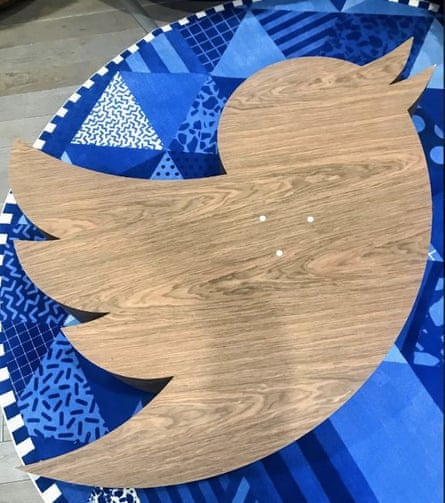 A plain wooden table, possibly with a veneer, in the shape of the Twitter bird logo