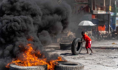 A protestor adds a tire to a burning barricade during a police demonstration to protest the recent killings of six police officers by armed gangs, in Port-au-Prince, Haiti, January 26, 2023.