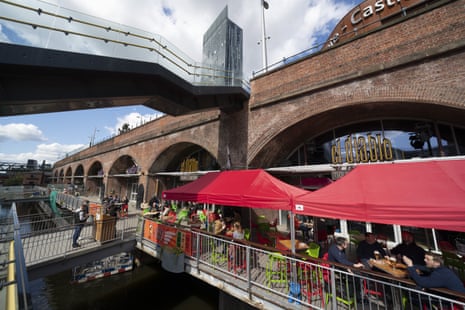 Customers sit outside a bar and restaurant in Manchester today