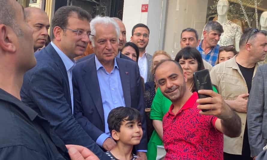 Ekrem İmamoğlu (in glasses) poses for a photograph with supporters on a walkabout
