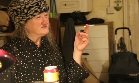 Helen, in fake-fur leopardskin hat, smoking, with a can of Special Brew.