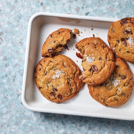Chocolate chip cookies on a tray, one with a bite taken out