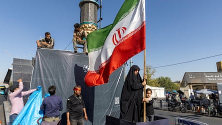 A woman holds the Iranian flag in Tehran