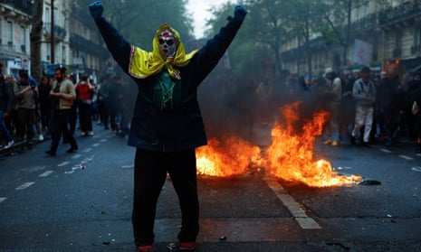 People demonstrate on the streets of Paris as this year's May Day protests coincide with weeks of public outrage over a pension-reform law.