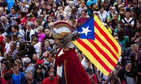A statue holding an independence flag is carried through Plaça Sant Jaum, Barcelona, during a pro-referendum rally.