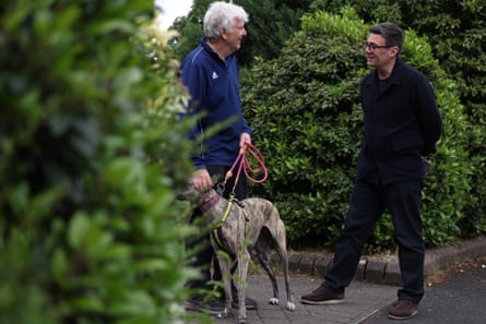 Andy Burnham talks to a person with a dog on his drive