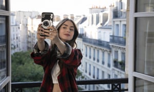 Lily Collins takes a selfie in Emily in Paris.