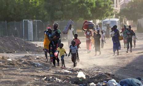 People, carrying babies and bags of possessions, flee their neighbourhoods amid fighting between the army and paramilitaries in Khartoum last week.