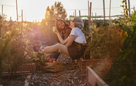 Two women relaxing and chatting at an allotment.