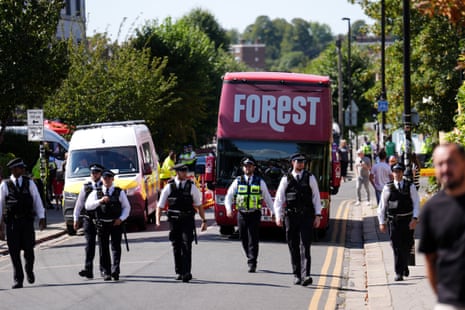 The Nottingham Forest team bus trundles along behind a line of police