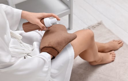 Self-tanning. Woman applying cosmetic product on to tanning mitt indoors, above view