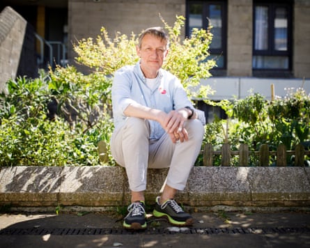 Richard Olszewski sits on a low wall on a sunny day