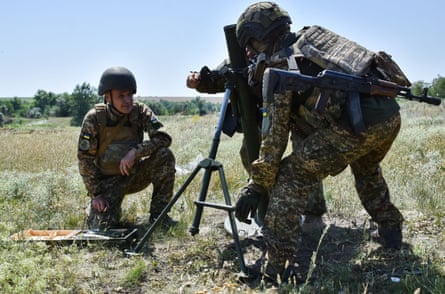 Ukrainian national guard soldiers prepare to fire a mortar