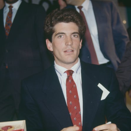 John Kennedy Junior in a navy suit with white shirt and a red patterned tie. Image taken in 1988.