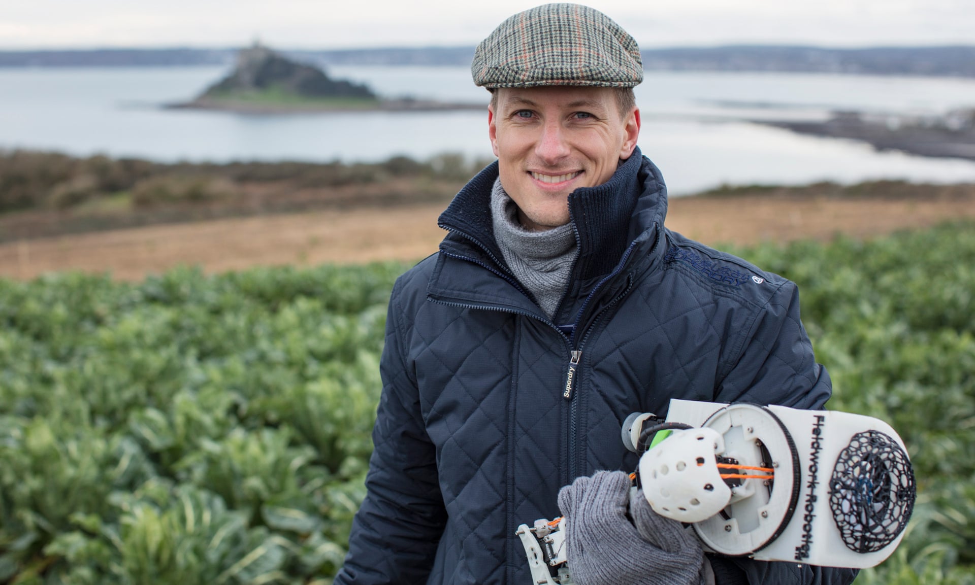 Photo of Dr. Martin Stoelen in a field with a robotic prototype