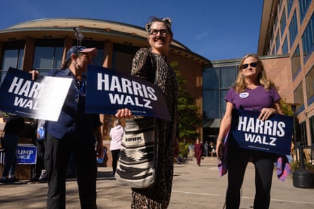 people hold signs that read ‘Harris Walz’