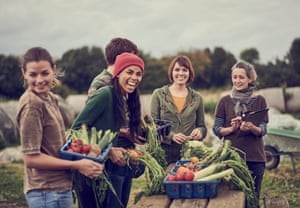 Community farming peers standing together with the allotment produce.