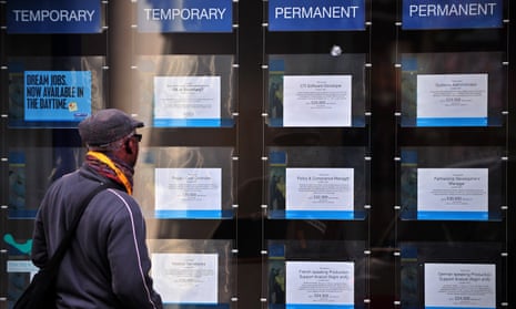 A man looks at job adverts in the window of a recruitment centre