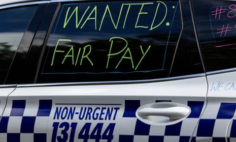 A sign of protest that reads 'Wanted: fair pay' is written on a police car during a Victorian police press conference about police pay.