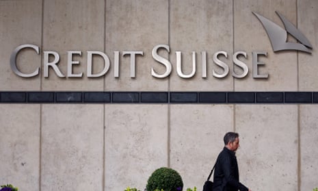 A person walks past the Credit Suisse office in Canary Wharf in London