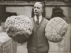 A man holding up two giant Mediterranean sponges for auction at Cutler Street warehouse