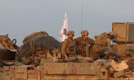 Israeli soldiers aboard a military vehicle at an area near the Israeli-Gaza border in southern Israel. More than 20,000 Palestinians and at least 1,300 Israelis have been killed, according to the Palestinian Health Ministry and the Israel Defense Forces.