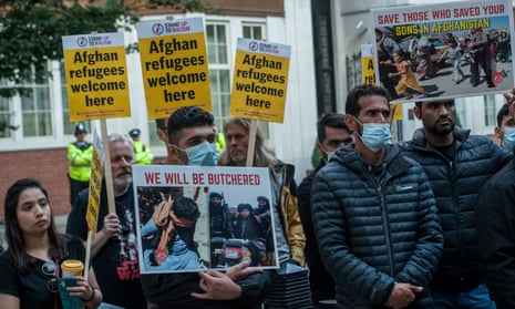 Demonstrators hold placards as Afghans living in London and their supporters attend a protest called by Stand Up To Racism.