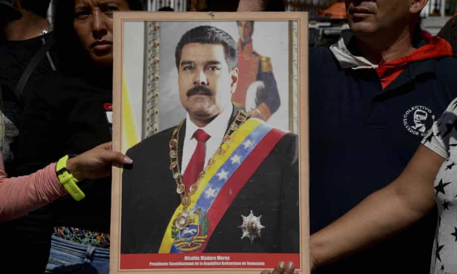 Supporters of Venezuela’s President Nicolás Maduro hold a portrait of him during a rally in Caracas on Monday.