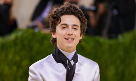 Timothée Chalamet on the red carpet in a tailored pale satin tuxedo