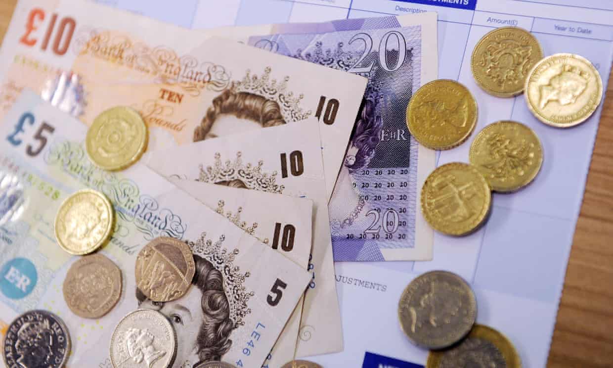 Notes and coins on a payslip.