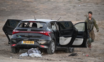 Israeli soldiers continue the search for ID and belongings among the cars and tents at Supernova