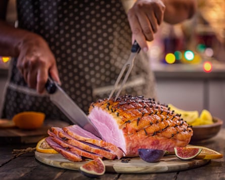 Carving a delicious glazed holiday ham with cloves