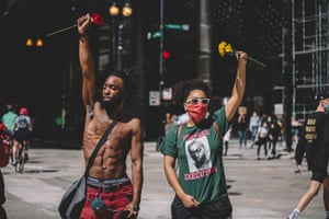 Chicago Protesters hold roses in solidarity after police escalated violence against protesters on Saturday
