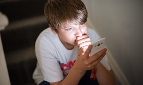 young boy looking at an iPhone