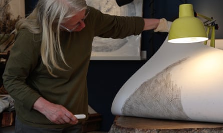 Branigan lifting up a large piece of paper from the section of trunk, showing the print.
